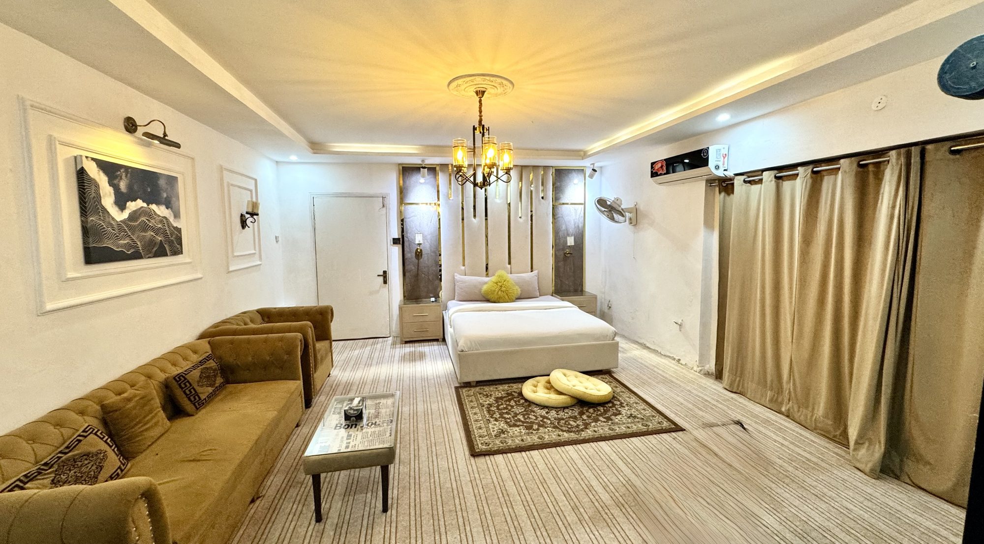 Spacious guest suite with chandelier, sofa and double bed